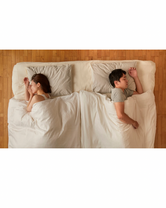 A couple in bed but lying apart to show their lack of intimacy 
