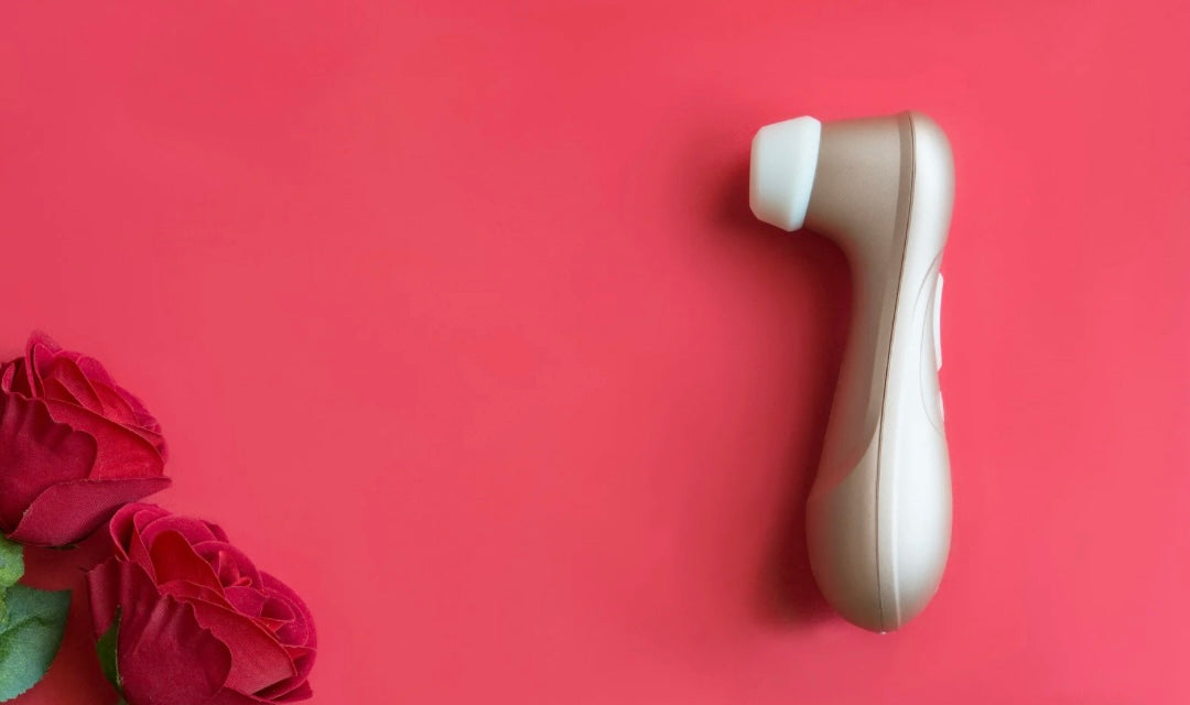 Forget dinner and a movie — turn date night into a pleasure ritual with these 3 sex toys for couples. Perfect for connection, foreplay, and unforgettable nights in. A sex toy on a red background with red roses in the corner